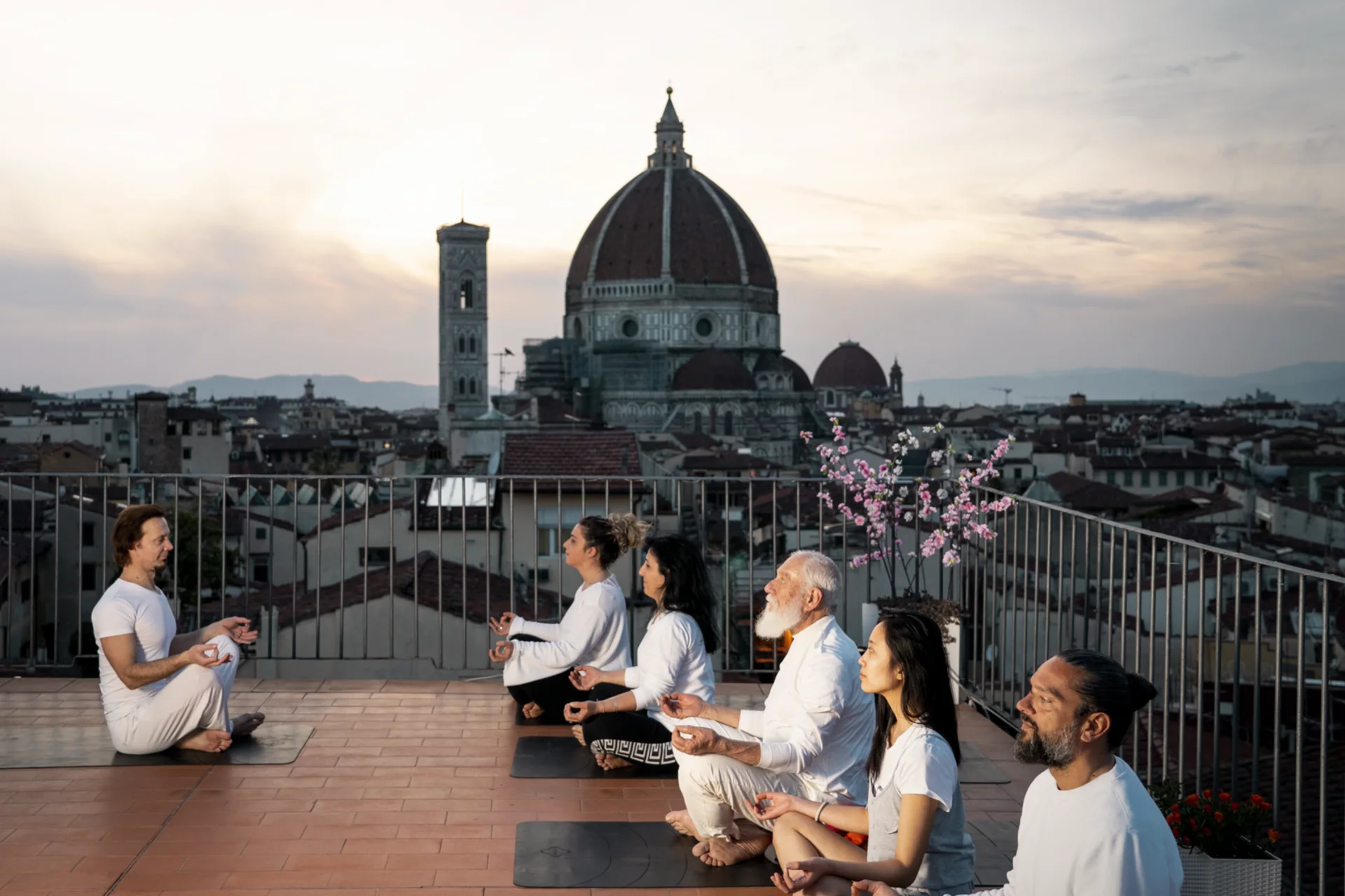 Guests enjoying a rooftop yoga session overlooking Florence Cathedral